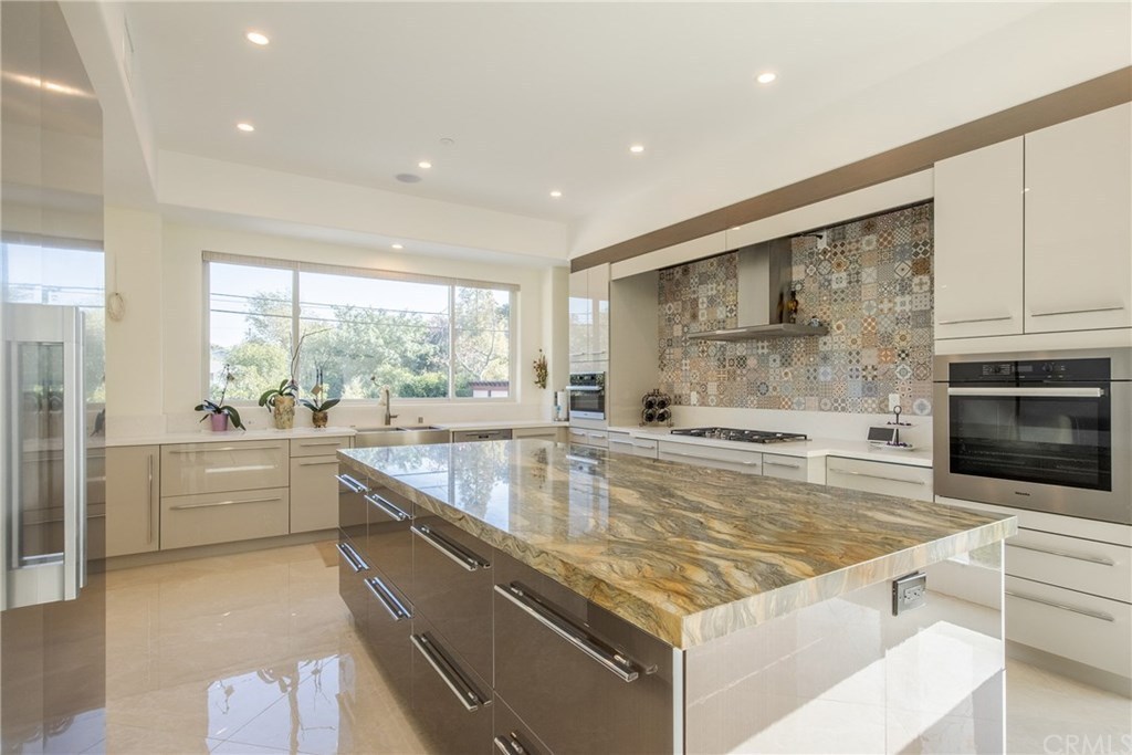 A kitchen with a marble floor and island